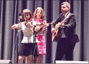 Leanna Price, left, Lauren Price Napier, center, and Scott Napier, right, perform on stage aboard the Royal Caribbean Ovation of the Seas.