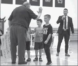 Delmas Moore, right, congratulates two young Blue Devils for their class’ success during the Rally for Life May 16 at Beallsville High School.